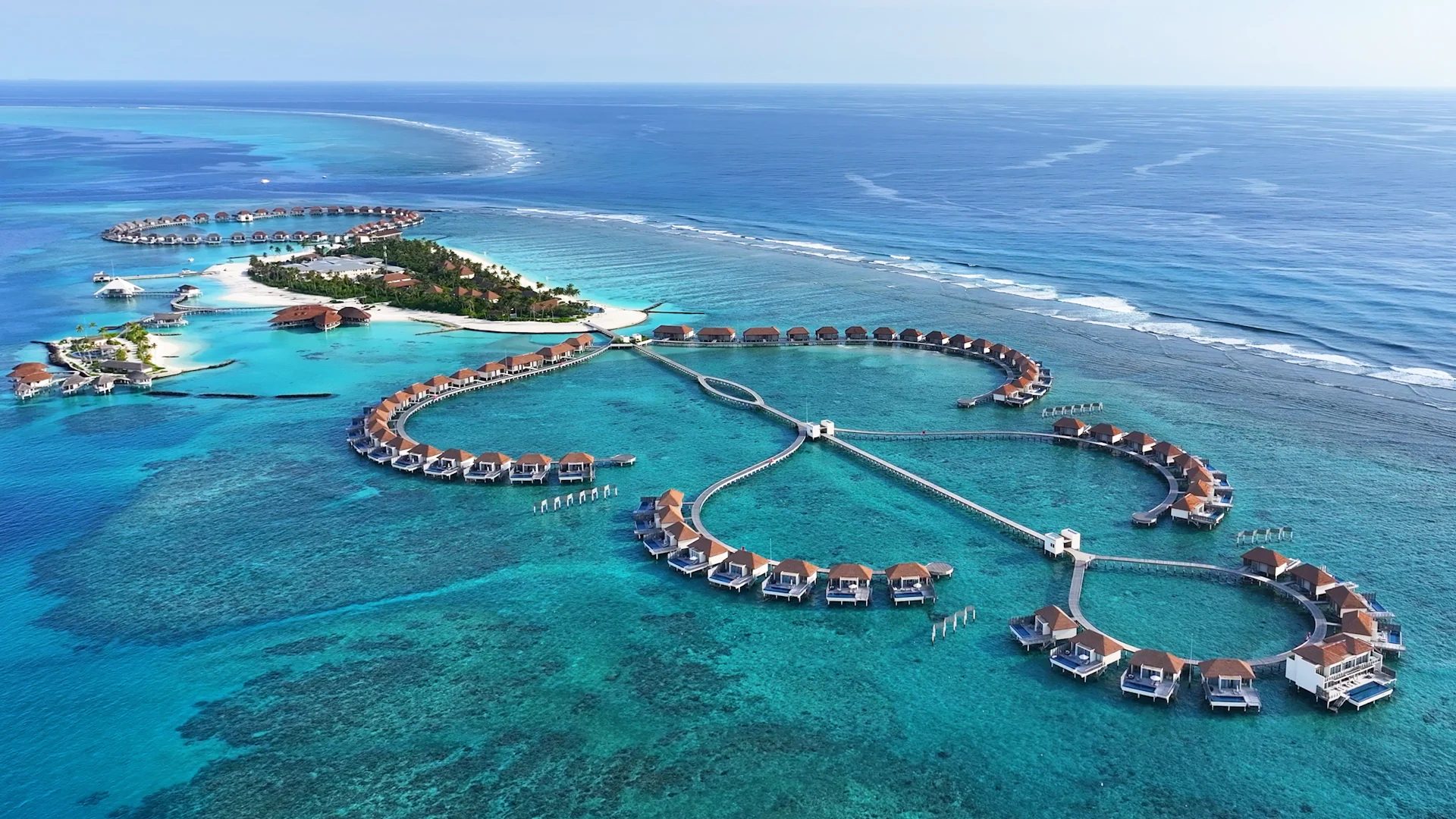 Aerial view of overwater villas in the Maldives with turquoise lagoon